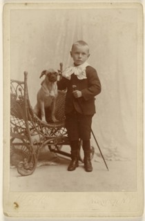 Little boy standing, holding a cane, with a little dog in a wicker chair; G. Wick, American, active Norwich, New York 1870s