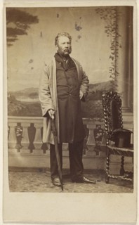 bearded man, holding an umbrella, standing; John Urie, Scottish, 1820 - 1910, active Glasgow, Scotland, 1862 - 1865; Albumen