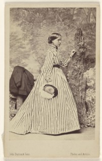 woman wearing a striped dress, holding a hat, standing; John Burton & Sons; 1864; Albumen silver print