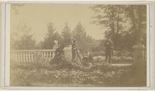 Five  people: three women and one man standing, one man seated, in a garden; 1865 - 1870; Albumen silver print