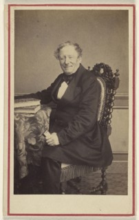 man seated at a table with books on top; Emile Renaut, French, active Chaumont, France 1860s, 1870 - 1875; Albumen silver print