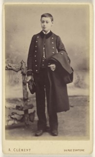 well-dressed young boy standing, holding his cap in his right hand, his coat over his left arm; A. Clément, French, active 1860s