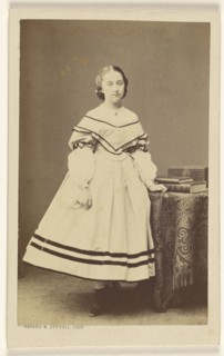 woman standing near a table with books on top; Bayard & Bertall; 1865 - 1875; Albumen silver print