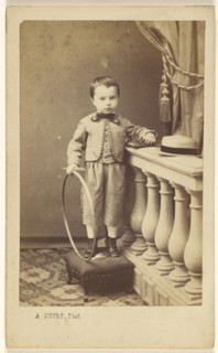 little boy standing on an ottoman, holding a hoop; A. Dupré, French, active 1860s, 1865 - 1875; Albumen silver print