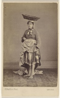 woman of Bayonne, France, wearing her native costume, standing, with a basket on top of her head; Ferdinand Berillon French