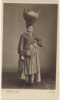 woman of Bayonne, France, wearing her native costume, standing, with a large ceramic pitcher on her head; Ferdinand Berillon