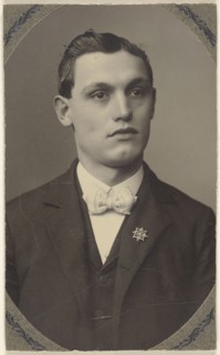 young man wearing a white bow tie and a pin on his lapel; 1875 - 1880; Platinum print
