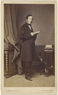 man with long sideburns standing with an open book; Herbert Ogg & Company; about 1865; Albumen silver print