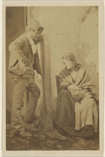 Man with round cap standing next to a seated woman with baby; 1865 - 1870; Albumen silver print
