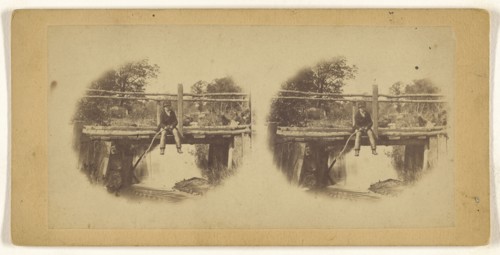 Boy fishing from a bridge, printed in vignette-style; about 1865; Albumen silver print