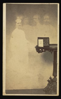Female  spirit  with three male  spirits  next to table with a cabinet card propped against an album; Attributed to William H