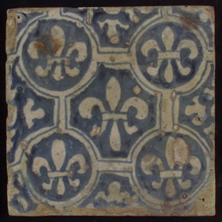Two-tone tile, blue on white background, four circles with white French lily around central ornament with lily, wall tile