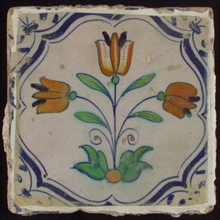 Tile, three-tier in blue, green, orange and purple on white, inside frame with accolades, corner motif, wing, wall tile