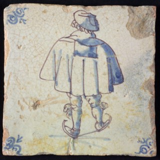 Figure tile, blue with skating man, with wide cape, seen on the back, corner pattern ox head, wall tile tile sculpture ceramic