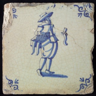 Occupation tile, blue with hawker with chest with merchandise on the hip, corner motif ox's head, wall tile tile sculpture