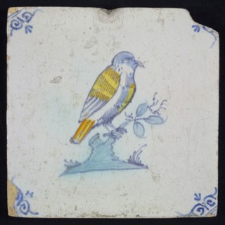 Animal tile, bird on branch to the right in yellow, orange, green and blue on white, corner pattern ossenkop, wall tile