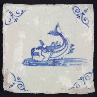 Animal tile, unknown fish in water to the left with open beak and curled tail, in blue on white, corner motif steered ox's head