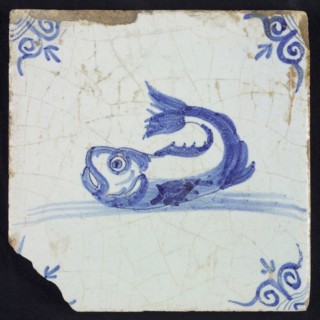 Animal tile, unknown fish in water to the left with open beak and curled tail, in blue on white, corner motif oxen head, wall