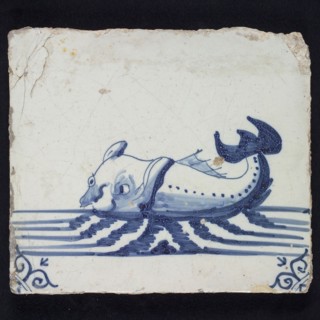Animal tile, sea-washed in continuous water to the left, in blue on white, corner motif of ox-head, wall tile tile sculpture