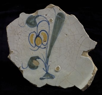 Fragment of the majolica dish, polychrome, tulip or snowdrop on the ground, plate crockery holder soil find ceramic earthenware