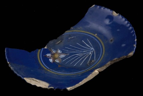 Fragment of saucer dish, dark blue ground, on the mirror polychrome flower (daffodil?), plate crockery holder soil find ceramic