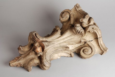 Carved wooden console from the façade of house, console building element carvings sculpture visual material wood gypsum paint