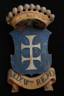 Carved wooden crowned coat of arms including the name Fred.K Wm. Remy, coat of arms information form wood carving sculpture