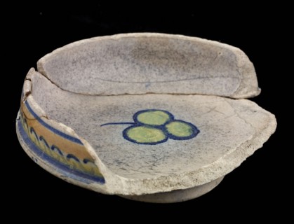 Fragment of the majolica trough, yellow, orange and blue on white, exterior rim with wave motif, inside mirror trilobal leaf