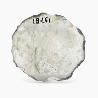 Oval glass disk of thin window glass, disc artifact soil find glass, cast cut cut Oval slice thin window glass