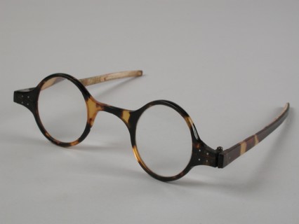 Glasses with round lenses on strength, frame of yellow-brown flamed tortoise with narrow flat straight feathers, spectacles