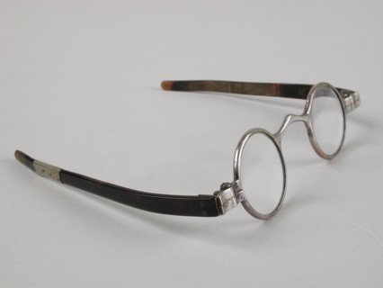 Glasses with round lenses on strength, silver-colored metal frame and short flat feathers of turtle, children's glasses
