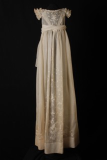 Long baptismal dress of white linen, V-shaped insert with white embroidered floral scrolls and little flowers, baptismal wear