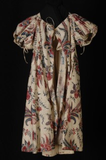 Empire children's dress or jacket of cotton chintz, white fond with large multicolored flowers, red, blue and purple, puff