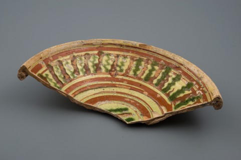 Fragment earthenware dish with green and brown silt decoration on yellow ground, plate dish crockery holder soil find ceramic