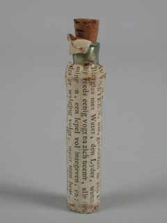 Transparent glass bottle with vomit and label In this bottle are six Greinen BRAAKWYNSTEEN, bottle holder medicine pharmacy