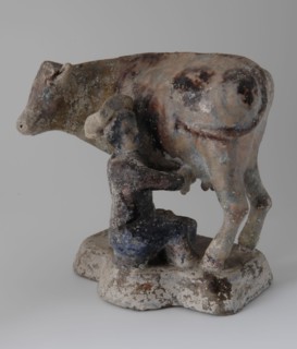 Standing cow with sitting milker in 18th century costume, damaged by fire from bombing Rotterdam May 1940, sculpture visual