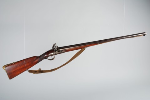 Double-barreled flint gun with two separate locks and tractors and wooden ramrod with legs tapping block and textile carrying