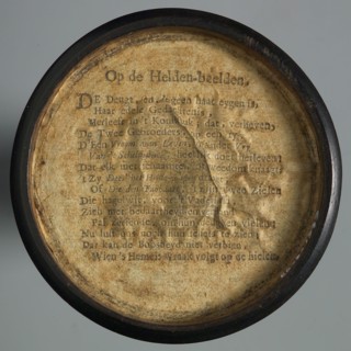One-sided wooden medallion, covered with paper, with printed text OP DE HELDEN-BEELDEN, penny box holder of wood paper, Text