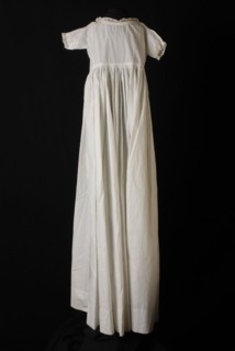 Long wide-sloping baby slip dress in white cotton, narrow edge along the neck and short sleeves, with christening dress
