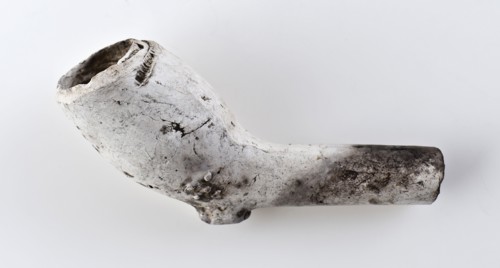 White clay pipe, unnoticed, with smooth handle and stylized Tudor rose on the kettle, clay pipe smoking equipment smoke floor