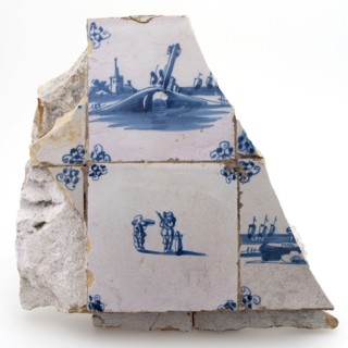 Wall fragment with tiles and tile fragments in blue on white ground, wall tile tile visual material earthenware ceramic