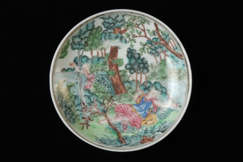 Dish of cup and saucer with lying woman and man in landscape in bushes, cup and saucer drinking utensils tableware holder