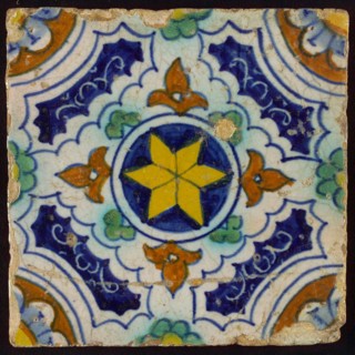 Ornament tile, blue, green, brown and yellow on white, central yellow star in circle, sgraffito surfaces, corner motif, quarter