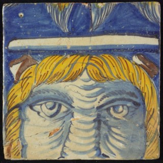 Tile of chimney pilaster, blue, yellow, brown on white, three-quarter head with strands of yellow hair and brown horns, white