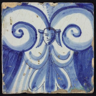 Tile of chimney pilaster, blue on white, part of pillar with capitals with curly ornament centered around maskon, chimney