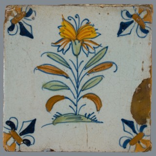 Flower Tile, flower on ground in orange, yellow, brown green and blue on white, corner pattern French lily, corner point orange