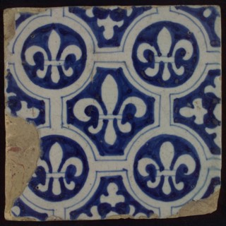 Two-tone tile, blue on white background, four circles with white French lily around central ornament with lily, wall tile