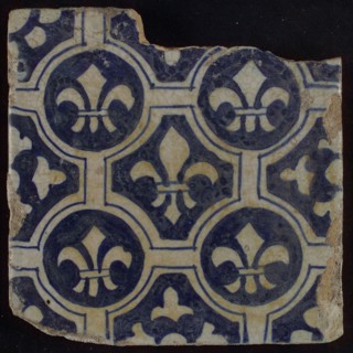 Two-tone tile, blue on white background, four circles with white French lily around central ornament with lily, wall tile