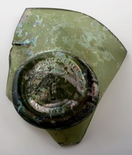 Fragment of the abdominal bottle on which seal with Bacchus on the barrel and round, belly bottle bottle holder soil find glass