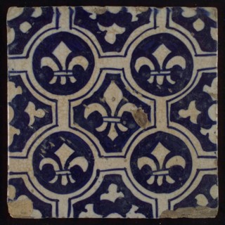 Two-tone tile, blue on white background, four circles with white French lily around central ornament with lily, wall tile